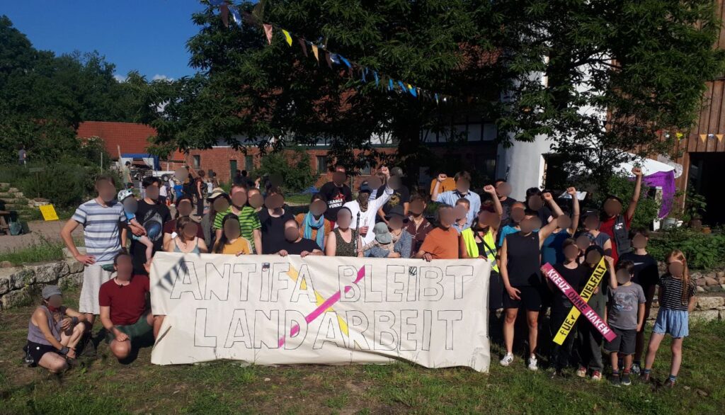 Menschen halten ein Banner hoch, auf dem steht: Antifa bleibt Landarbeit